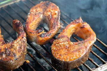 Three pieces of fish are on a grill