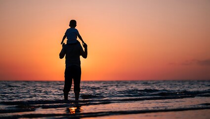 Silhouette of a father carrying his child on his shoulders at sunset on a beach with ocean waves