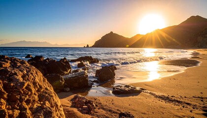 Sunrise over a tranquil beach with rocks