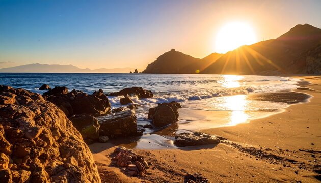 Sunrise over a tranquil beach with rocks