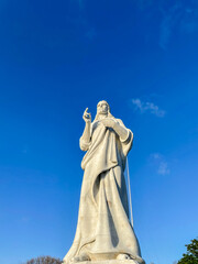 Marble statue of Christ in Havana, Cuba. Low angle view against a clear blue sky