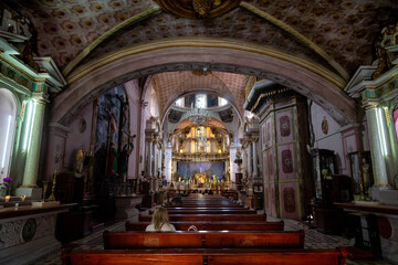 Naklejka premium Interior of Oratorio de San Felipe Neri with vaulted ceiling, dome, altar and seated visitor in San Miguel de Allende