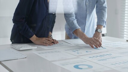 Professional business team analyzing financial reports, sharing insights and planning strategic decisions in modern workplace setting