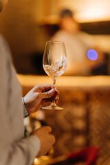 Elegant hand holding wine glass during sparkling wine tasting at a stylish bar
