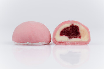 Pink mochi ice cream with berry filling, cut in half, isolated on white background