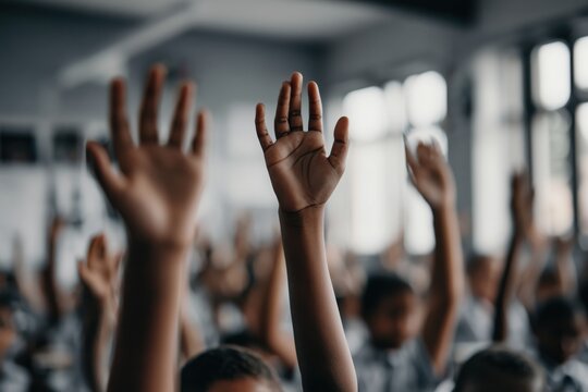 Audience members raising hands in a modern conference room