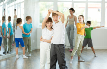 Fototapeta premium Preteen girls and boys learn to dance classical dances in a choreographic studio