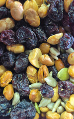 Detailed close-up photo of a colorful mix of roasted corn, peanuts, sunflower seeds, pumpkin seeds, and dried cranberries