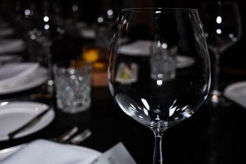 Elegant glassware on a beautifully set dining table, showcasing fine dining elements, with decorative plates and ambient lighting for a sophisticated restaurant celebration