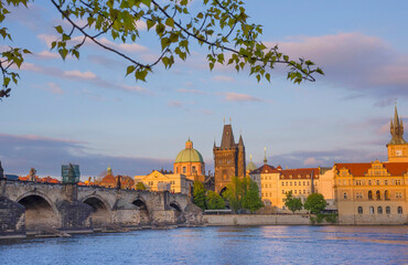 View of old town with Charles Bridge (Karluv Most) on Vltava river and Old Town Bridge Tower, famous tourist destination in Prague, Czech Republic (Czechia), at sunset