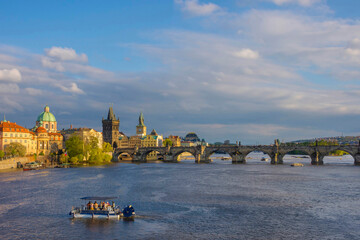 Charles Bridge (Karluv Most) on Vltava river and Old Town Bridge Tower, famous tourist destination in Prague, Czech Republic (Czechia), at sunset