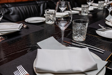 Elegant restaurant table setting featuring fine glassware, neatly folded napkins, and decorative plates, creating a sophisticated dining atmosphere for celebration and serving ideas