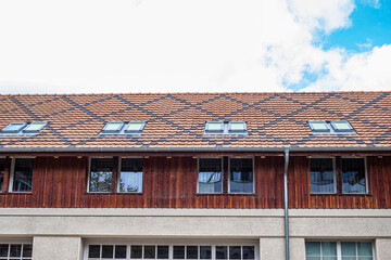 Traditional tiled roof showcasing durable materials and architectural design, featuring windows and wooden elements, emphasizing shelter and protection in residential construction