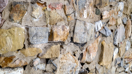 Close-up of a natural stone wall showing textured masonry and detailed stone patterns