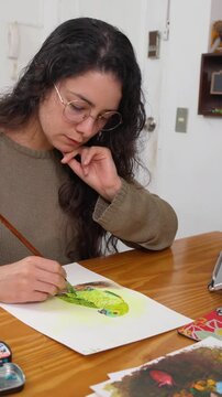 Graphic designer painting parrot in home studio