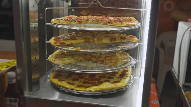 Assorted Savory Pizzas Spinning in Heated Display at Fair 3170