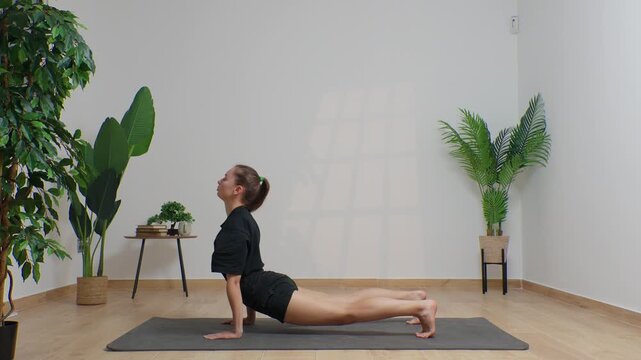 High-definition footage of a female instructor performing a variety of full-body yoga poses on a bright, neutral backdrop. Clean, minimalist composition and soft studio lighting highlight balance, fle