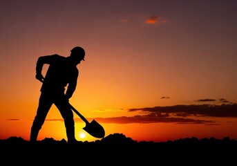 Silhouetted worker digging with shovel at sunset image