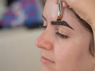 Caucasian woman getting eyebrow tinting procedure. 