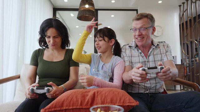 Granddaughter guide grandmother how to play console game with grandfather. Senior use technology activity communicate new generation kid cross generation gap strengthen family bond. Divergence.