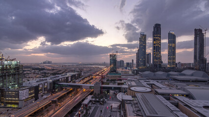 Fototapeta premium Aerial view of Financial center road night to day timelapse with under construction building