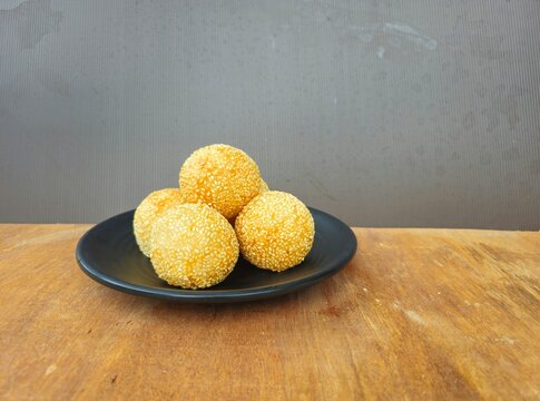potatoes on a plate,Sesame balls or Onde onde or Jiandui or Kue moci or Kuih bom,a type of Chinese pastry,made from glutinous rice,coated with sesame seeds,filled with a filling usually beans,served w