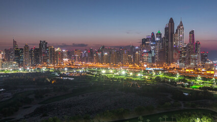 Fototapeta premium Dubai Marina skyscrapers and golf course day to night timelapse, Dubai, United Arab Emirates