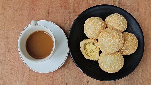 cup of coffee and cookies,Sesame balls or Onde onde or Jiandui or Kue moci or Kuih bom,a type of Chinese pastry,made from glutinous rice,coated with sesame seeds,filled with a filling usually beans,se