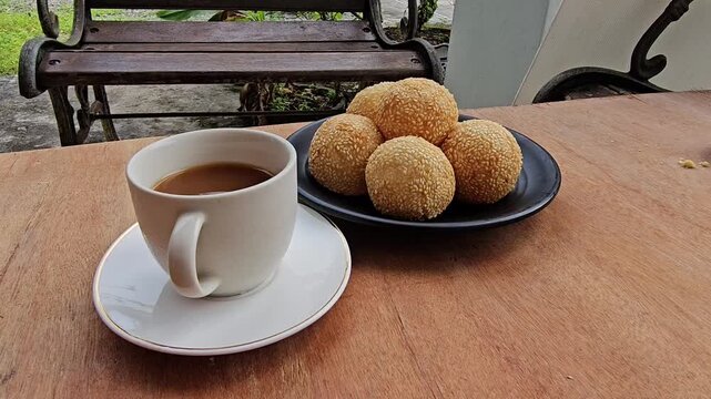 coffee and cookies,Sesame balls or Onde onde or Jiandui or Kue moci or Kuih bom,a type of Chinese pastry,made from glutinous rice,coated with sesame seeds,filled with a filling usually beans,served wi