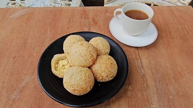 coffee and cookies,Sesame balls or Onde onde or Jiandui or Kue moci or Kuih bom,a type of Chinese pastry,made from glutinous rice,coated with sesame seeds,filled with a filling usually beans,served wi