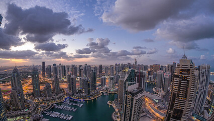 Obraz premium Dubai Marina skyscrapers and jumeirah lake towers view from the top aerial night to day timelapse in the United Arab Emirates.