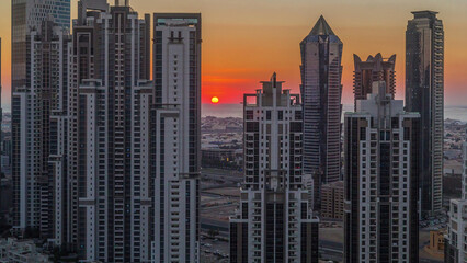 Modern residential and office complex with many towers aerial timelapse at sunset in Business Bay,...