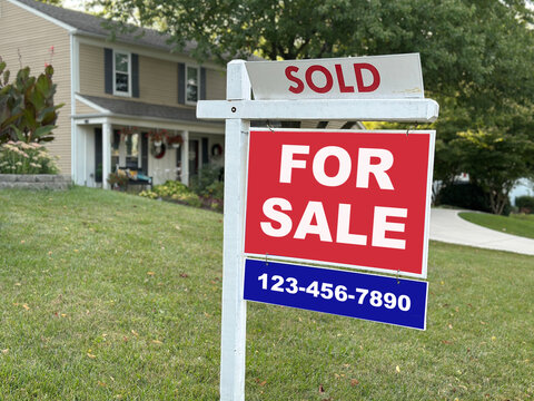 House with Sold and For Sale Sign in Front Yard - Powered by Adobe
