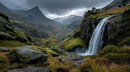 Fototapeta premium Icelandic waterfall crashing into mossy cliffs, rainbow in the mist, dramatic overcast sky, wide panoramic composition