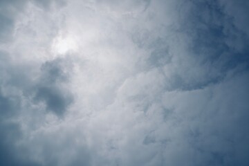 Soft cloudy sky with bluish tones and subtle sunlight peeking through, representing calm before the storm.