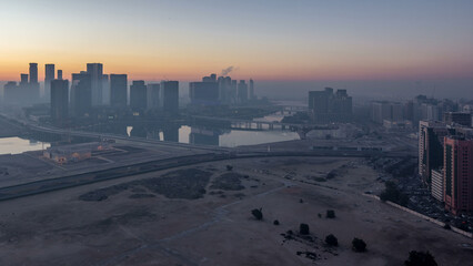 Abu Dhabi city skyline with skyscrapers before sunrise from above night to day timelapse