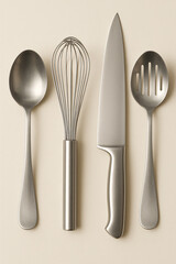 Professional kitchen utensils including chef knife, whisk, spoon, and slotted spoon arranged neatly