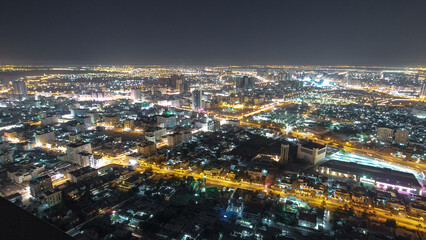 Fototapeta premium Cityscape of Ajman from rooftop night aerial timelapse