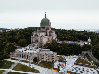 Aerial view of Saint Joseph's Oratory in Montreal at sunset, with cityscape and greenery. g.