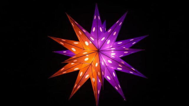 Glowing purple and orange paper star flickering on black background with soft light pulses, festive holiday video in vibrant colors for Christmas designs, party decor and seasonal storytelling