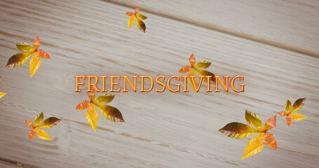 Fototapeta premium Image of friendsgiving text over autumn leaves on wooden background