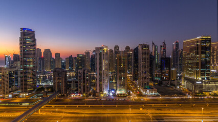 Fototapeta premium Dubai marina with traffic on sheikh zayed road panorama day to night timelapse lights turn on.