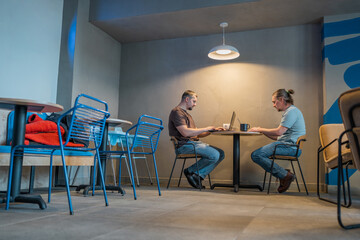 Two It Software engineers working on project and programming in coffee shop. Business people concept.