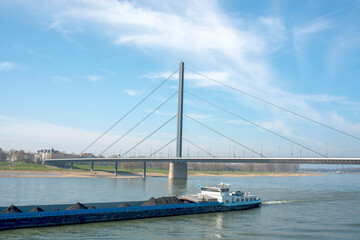 Modern Cable-Stayed Bridge with Cargo Ship Passing on River