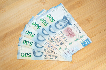 six mexican bills of 500 pesos over a wooden background