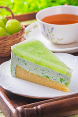 Pickled green mango mousse cake  on wooden tray with cup of tea