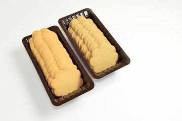 Two containers with delicious cookies on a white background