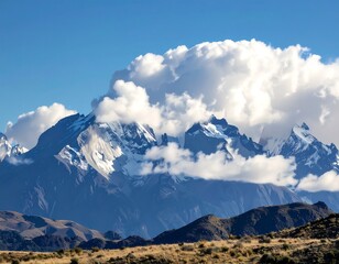 Fototapeta premium Majestic mountains, snow-capped peaks, fluffy clouds, clear sky