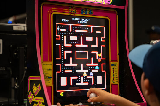 Player using joystick to play Ms. Pac-Man arcade machine. Toronto, Canada - August 16, 2025.