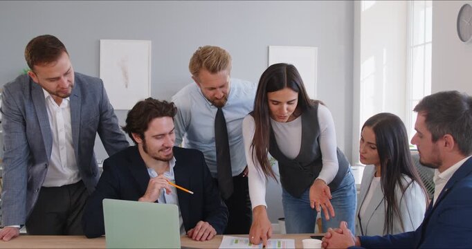 Young serious business man and female team leader coaching mentor planning, talk to diverse business people in office to explain new idea strategy at corporate group meeting, interns at briefing